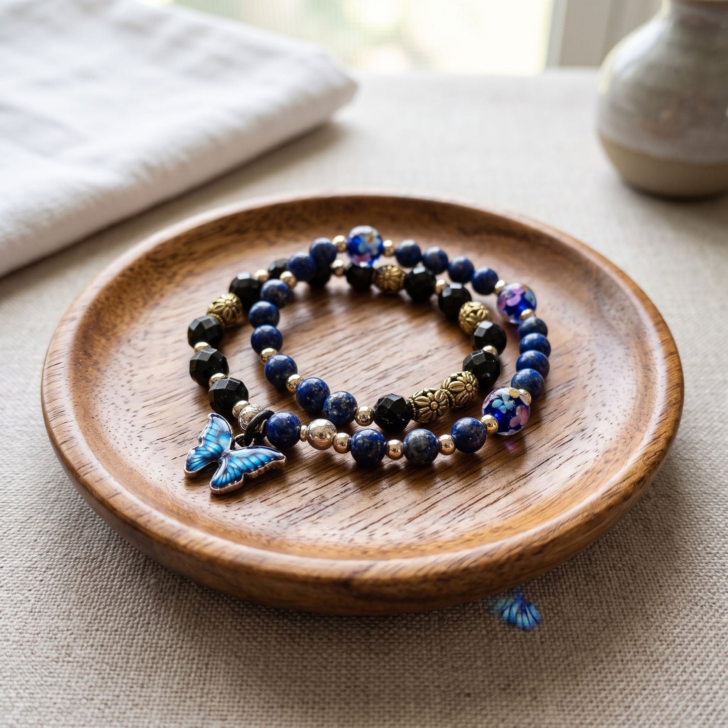 Blue Lapis bracelet displayed on a wooden jewelry dish with natural light and neutral background.