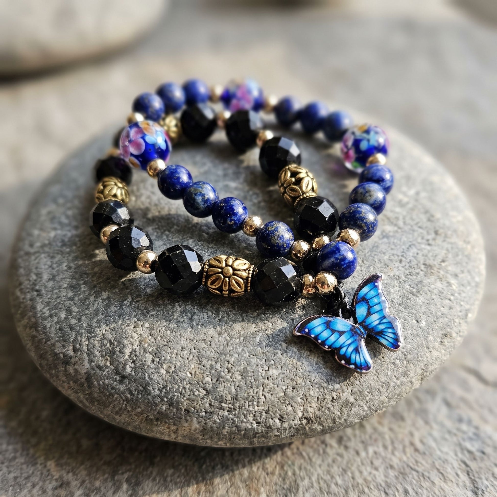 Close-up of Blue Lapis Dual Crystal Energy bracelet with butterfly clasp on a natural stone surface.